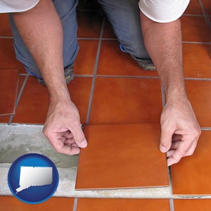 a tile worker laying ceramic floor tile - with Connecticut icon