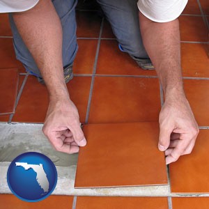 a tile worker laying ceramic floor tile - with Florida icon