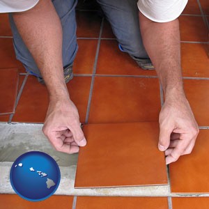 a tile worker laying ceramic floor tile - with Hawaii icon