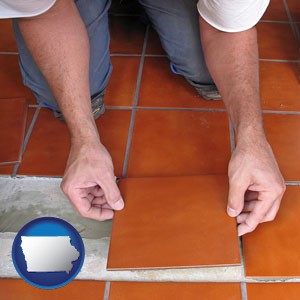 a tile worker laying ceramic floor tile - with Iowa icon