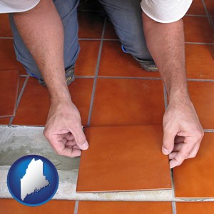 a tile worker laying ceramic floor tile - with Maine icon