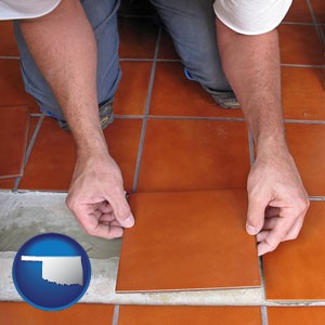 a tile worker laying ceramic floor tile - with Oklahoma icon