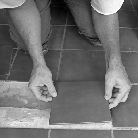 a tile worker laying ceramic floor tile